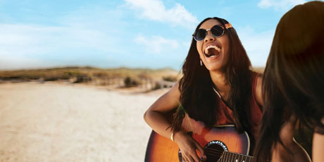Woman playing guitar on California beach