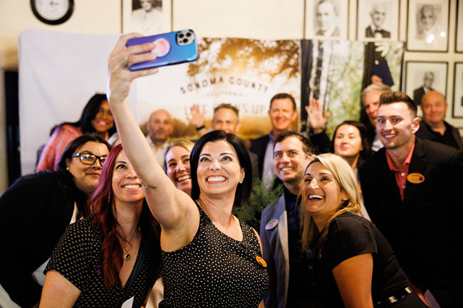 Associate VP of Global Brand Advertising Erika DiProfio snaps a selfie with staff